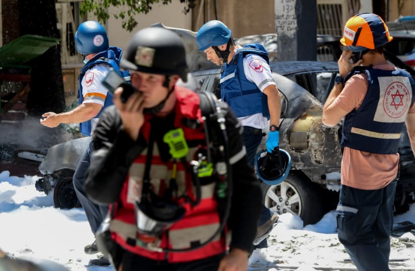 Police and rescue personnel at the scene of arocket hit  in Ramat Gan which was fired from the Gaza stripl, leaving one Israeli dead  on May 15, 2021. (photo credit: AVSHALOM SASSONI/ MAARIV)
