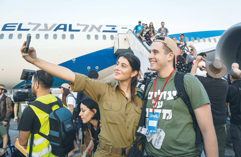 IMMIGRANTS FROM North America arrive at Ben-Gurion Airport on a flight arranged by Nefesh B’Nefesh.  (photo credit: FLASH90)