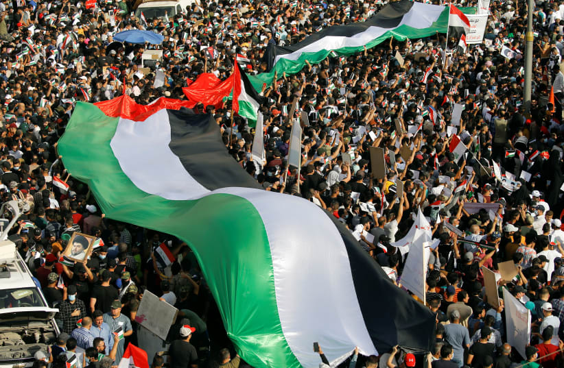 Iraqi demonstrators wave Palestinian flags during a protest to express solidarity with the Palestinian people amid a flare-up of Israeli-Palestinian violence, in Baghdad, Iraq May 15, 2021. (photo credit: KHALID AL MOUSILY / REUTERS)