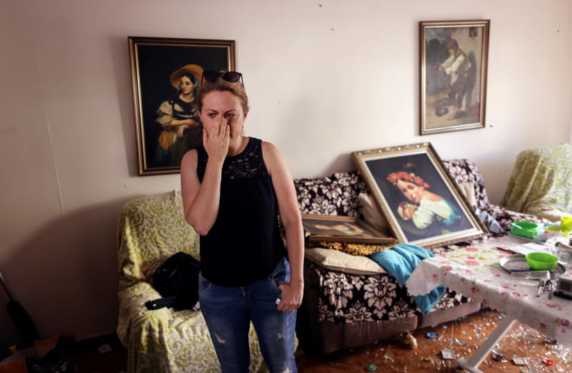 Sveta Shtilrman stands at her living room inside a damaged building following a rocket attack from Gaza, in Ashdod, Israel May 17, 2021.  (photo credit: REUTERS/Ronen Zvulun)