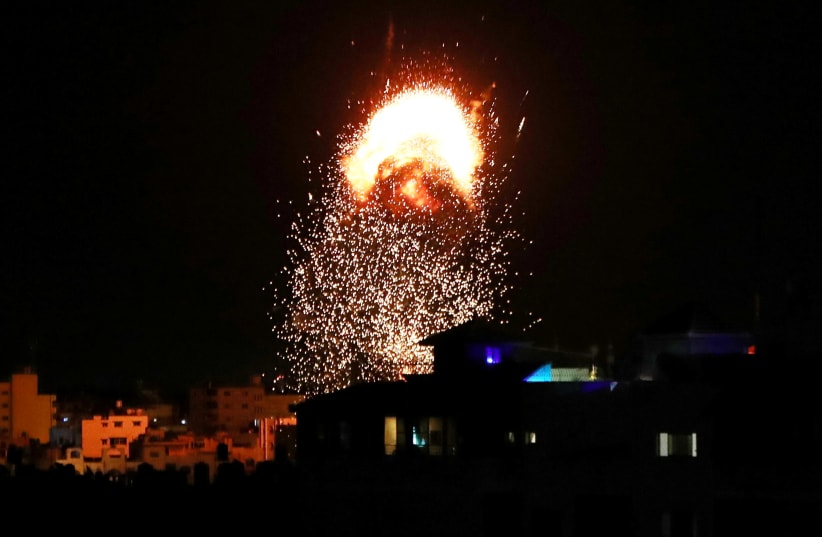 Smoke and flames are seen following an Israeli air strike on a building in the Gaza Strip  (photo credit: REUTERS)