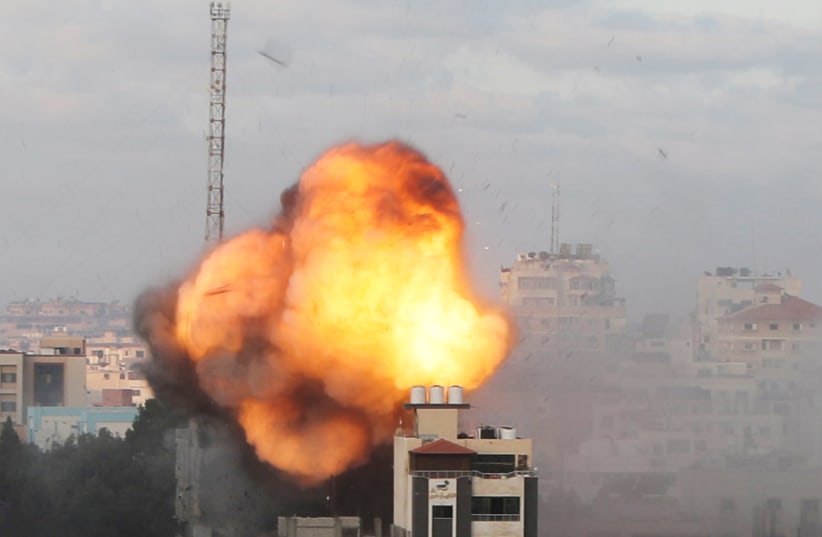 Smoke and flames are seen following an Israeli air strike on a building, amid a flare-up of Israeli-Palestinian fighting, in Gaza City May 18, 2021. (photo credit: MOHAMMED SALEM/REUTERS)
