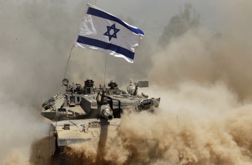 Israeli soldiers ride a tank after returning to Israel from Gaza, 2014 (photo credit: SIEGFRIED MODOLA/REUTERS)