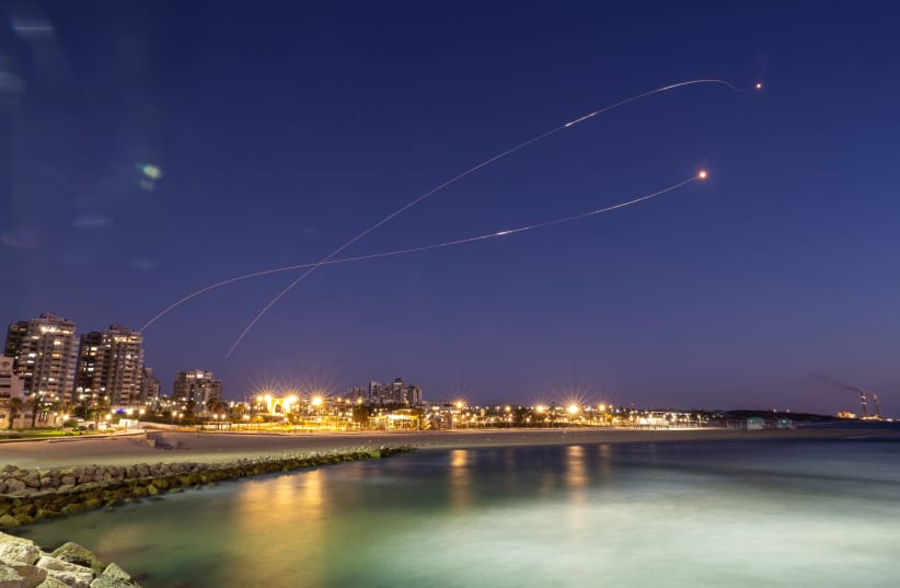 Streaks of light are seen as Israel's Iron Dome anti-missile system intercept rockets launched from the Gaza Strip towards Israel, as seen from Ashkelon May 19, 2021. (photo credit: AMIR COHEN/REUTERS)