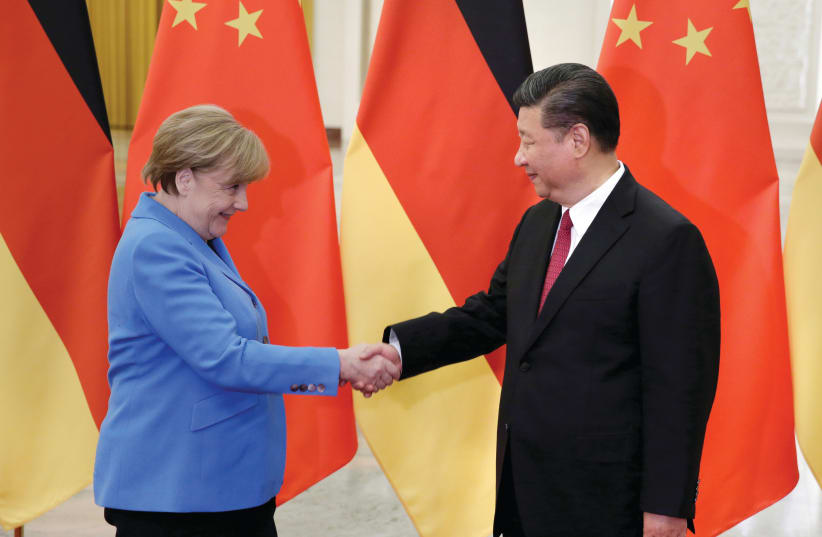 CHINESE PRESIDENT Xi Jinping meets German Chancellor Angela Merkel in Beijing in 2018. The book warns about democracies getting too close to China (photo credit: JASON LEE / REUTERS)