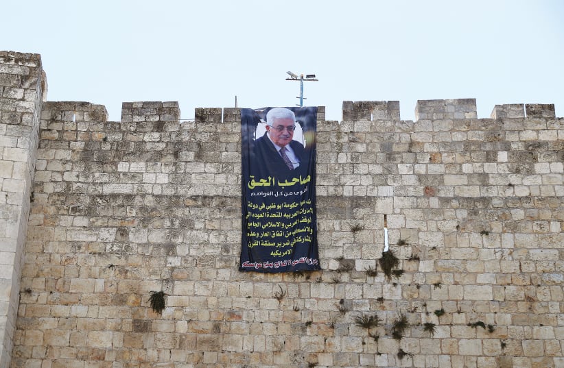 PALESTINIAN PRESIDENT Mahmoud Abbas is depicted on a banner hung on the walls of Jerusalem’s Old City last year. (photo credit: AMMAR AWAD/REUTERS)