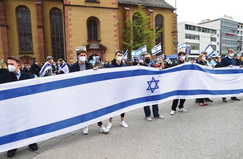 GERMAN DEMONSTRATORS hold a large Israeli flag in Frankfurt this week. (photo credit: KAI PFAFFENBACH/REUTERS)
