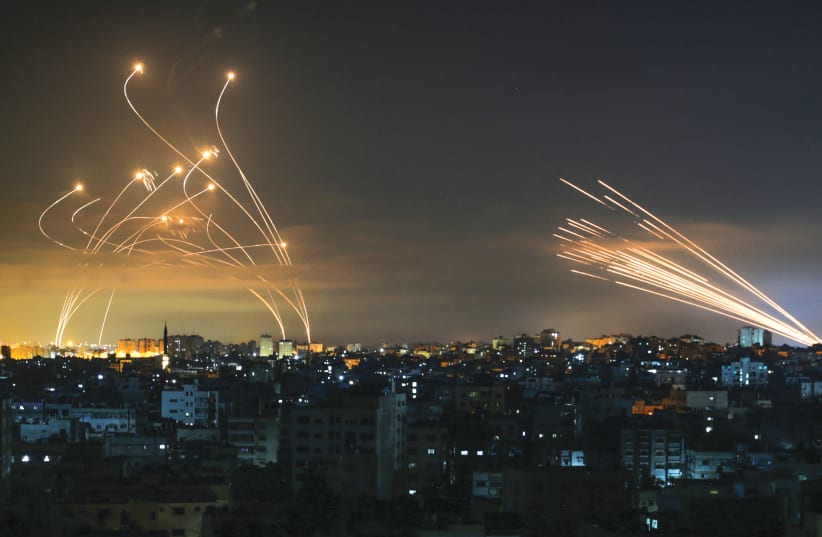 Iron Dome missile interceptors (left) launch at Hamas rockets (right) on their way from the Gaza Strip into Israel last week. (photo credit: ANAS BABA/AFP VIA GETTY IMAGES)