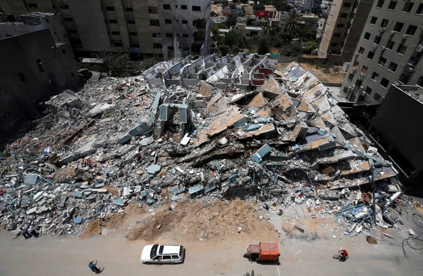A view shows the remains of a tower building destroyed by Israeli missile strikes in the recent cross-border violence between Palestinian militants and Israel, following Israel-Hamas truce, in Gaza City May 21, 2021. (photo credit: MOHAMMED SALEM/REUTERS)