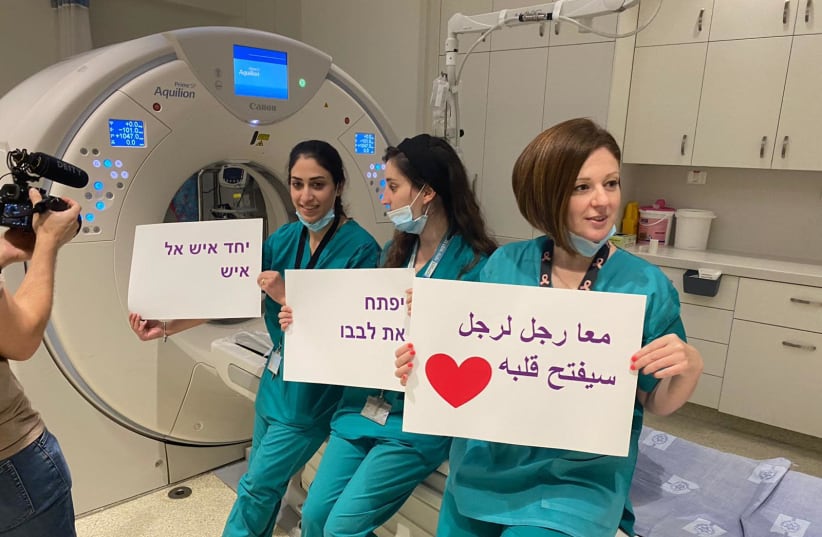 Hadassah Medical Center workers hold signs emphasizing cooperation.  (photo credit: Courtesy)