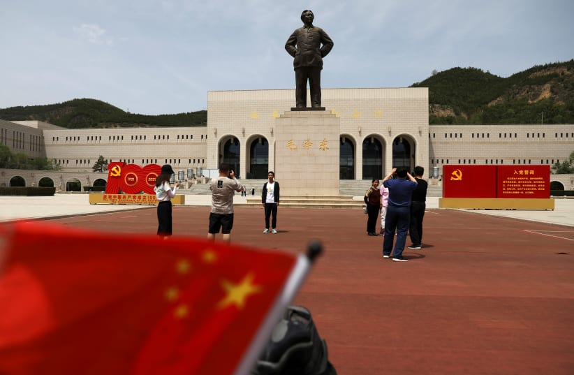 Visitors take pictures in front of a giant statue of late Chinese chairman Mao Zedong at Yanan Revolution Memorial Hall, ahead of the 100th founding anniversary of the Communist Party of China, during a government-organised tour in Yanan, Shaanxi province, China, May 10, 2021 (photo credit: REUTERS/TINGSHU WANG)