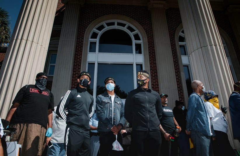 Supporters of the Georgia NAACP (National Association for the Advancement of Colored People) wearing protective masks protest after the death in February of Ahmaud Arbery, an unarmed young black man shot after being chased by a white former law enforcement officer and his son, at the Glynn County Co (photo credit: REUTERS/DUSTIN CHAMBERS)