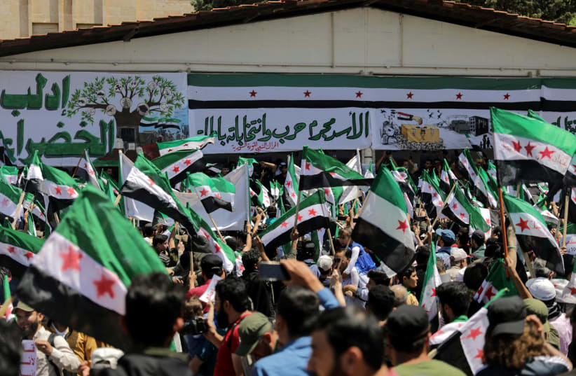 People take part in a demonstration against Syria's President Bashar al-Assad and presidential elections, in the opposition-held Idlib, Syria May 26, 2021. (photo credit: KHALIL ASHAWI / REUTERS)