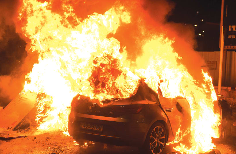 A CAR BURNS after it was set ablaze during clashes between Arabs and Jews in Acre on May 12.  (photo credit: RONI OFER/FLASH90)
