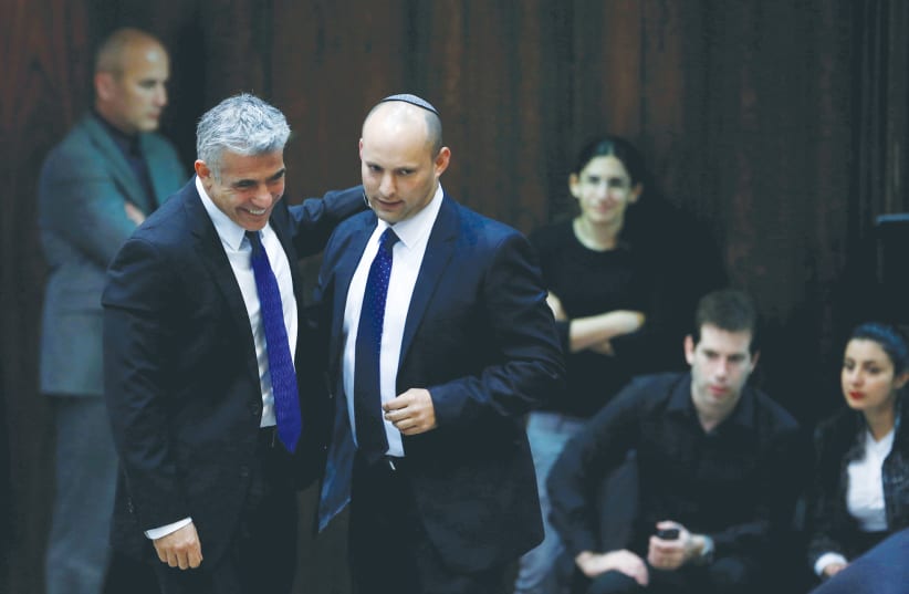 YAIR LAPID and Naftali Bennett walk together in the Knesset in 2013 (photo credit: BAZ RATNER/REUTERS)