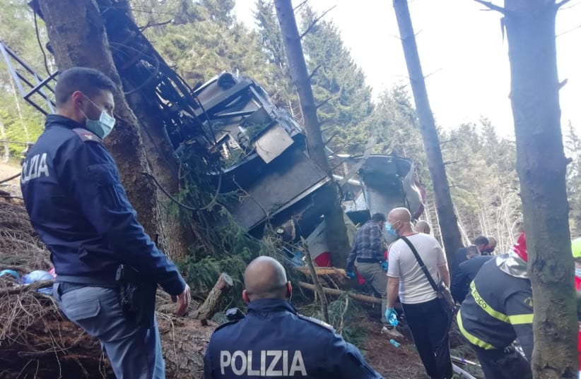 Police and rescue service members are seen near the crashed cable car after it collapsed in Stresa, near Lake Maggiore, Italy May 23, 2021. (photo credit: REUTERS)