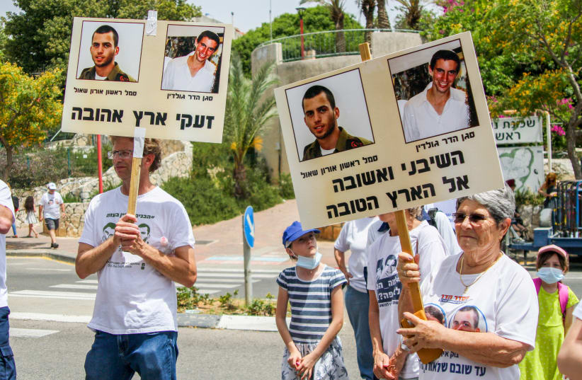Israelis attend a rally calling for the return of the remains of late Israeli soldiers Oron Shaul and Hadar Goldin from Hamas captives, near the home of Israeli Defence Minister Benny Gantz in Rosh Haayin, May 21, 2021.  (photo credit: FLASH90)