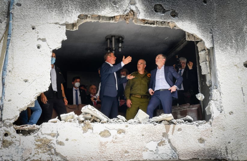 German Foreign Minister and Israeli Foreign Minister Gabi Ashkenazi visit at the site where a missile fired by Palestinian militants in Gaza hit a residential building in the central Israeli town of Petah Tikva, May 20, 2021. (photo credit: AVSHALOM SASSONI/FLASH90)