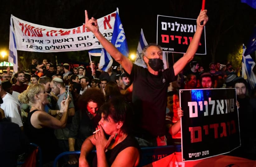 Pro-Netanyahu protesters hold up a sign which says "Leftist traitors" outside the home of Yamina MK Ayelet Shaked in Tel Aviv, May 30, 2021. (photo credit: AVSHALOM SASSONI/MAARIV)
