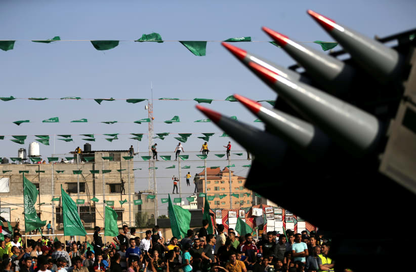 Palestinian Hamas supporters attend an anti-Israel rally as rockets are displayed on a truck by Hamas militants in Rafah, in the southern Gaza Strip May 28, 2021 (photo credit: REUTERS/IBRAHEEM ABU MUSTAFA)