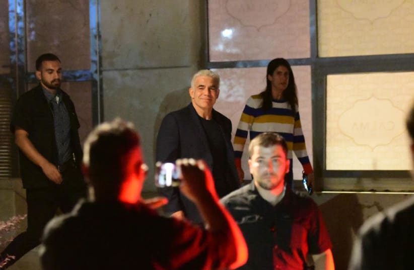 Yesh Atid leader Yair Lapid is photographed smiling while leaving the Kfar Maccabiah Hotel in Ramat Gan after officially announcing the formation of a coalition to replace Prime Minister Benjamin Netanyahu, on June 3, 2021. (photo credit: AVSHALOM SASSONI/MAARIV)