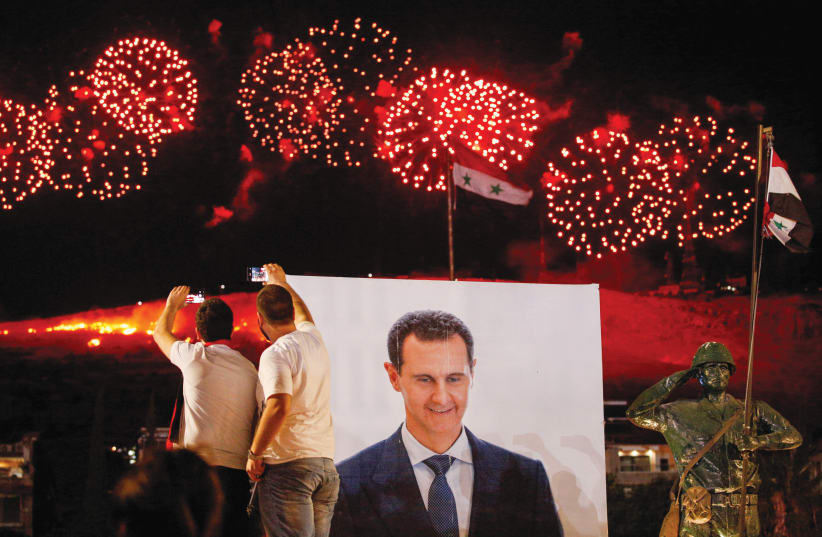 SUPPORTERS OF Syrian President Bashar Assad celebrate after he won a fourth term in office, in Damascus on May 27 (photo credit: REUTERS/OMAR SANADIKI)