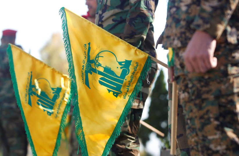 Hezbollah members hold flags marking Resistance and Liberation Day, in Kfar Kila near the border with Israel, southern Lebanon, May 25, 2021 (photo credit: REUTERS/AZIZ TAHER)