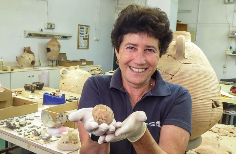 Israel Antiquities Authority archaeologist Alla Nagorsky with the egg that was retrieved. (photo credit: ASSAF PEREZ/ISRAEL ANTIQUITIES AUTHORITY)