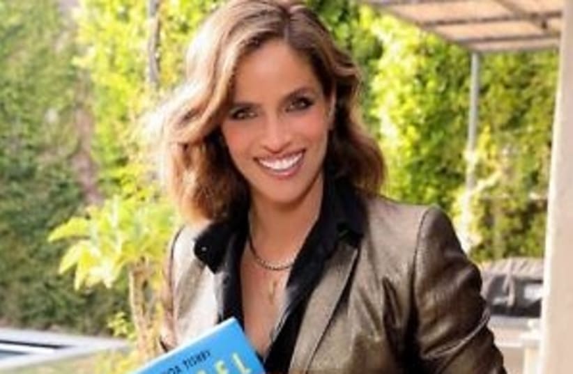 Noa Tishby holds a copy of her new book at a launch event in Los Angeles in April (photo credit: RICH FURY)