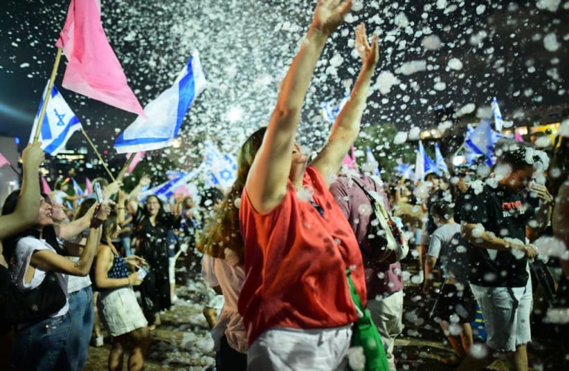 Protesters celebrate the end of Benjamin Netanyahu's 12-year reign as Prime Minister in Tel Aviv's Rabin Square. June 13, 2021. (photo credit: AVSHALOM SASSONI)