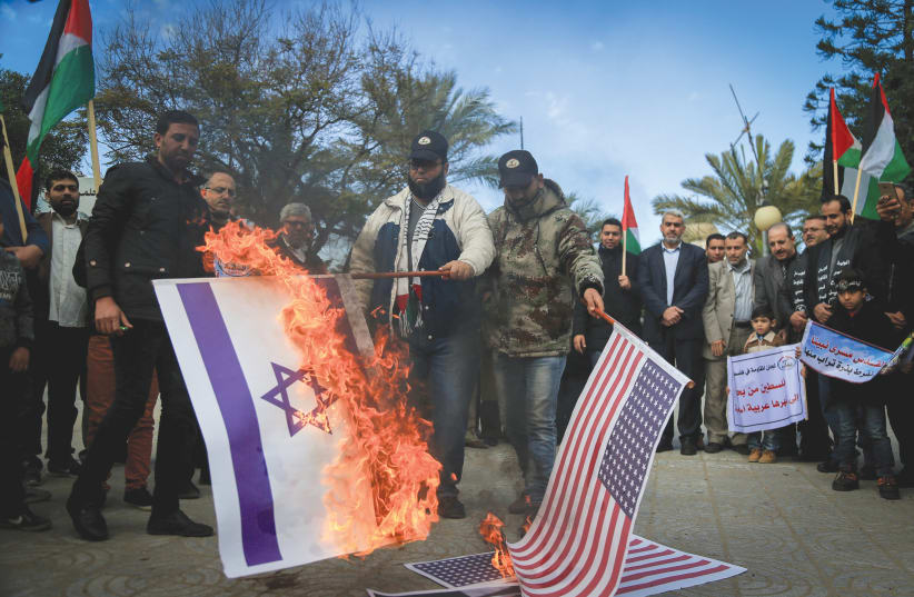 PALESTINIANS BURN an Israeli flag and a US flag during a protest in Gaza City in 2017. (photo credit: ABED RAHIM KHATIB/FLASH90)