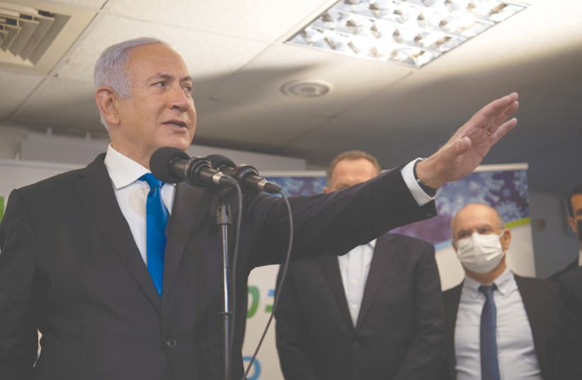 THEN-PRIME MINISTER Benjamin Netanyahu visits a coronavirus vaccination facility in Nazareth, ahead of the election in January. (photo credit: GIL ELIYAHU/REUTERS)