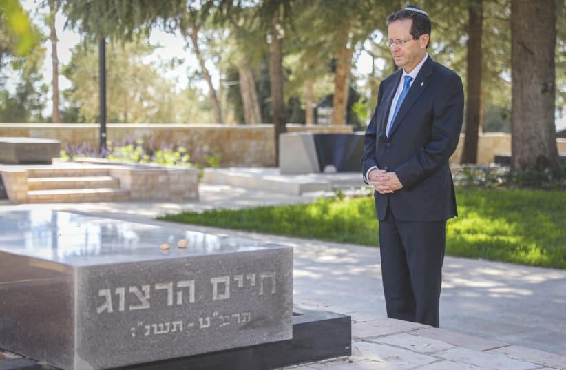 NEWLY ELECTED President Isaac Herzog visits the grave of his father, Chaim Herzog, at Mount Herzl Cemetery in Jerusalem earlier this month. (photo credit: NOAM REVKIN FENTON/FLASH90)