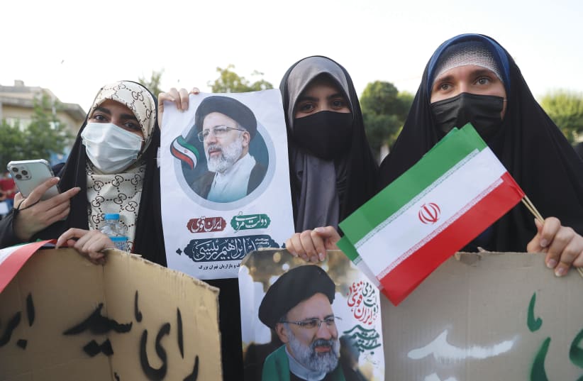 SUPPORTERS OF Iranian presidential candidate Ebrahim Raisi hold posters of him during an election rally in Tehran last week. (photo credit: MAJID ASGARIPOUR/WANA/REUTERS)