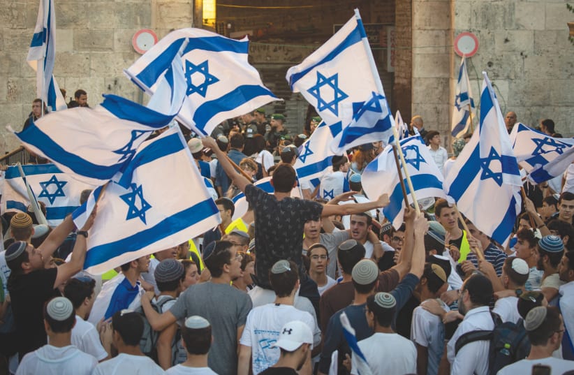 ISRAELIS WAVE flags as they dance next to Damascus Gate in Jerusalem’s Old City last Tuesday (photo credit: OLIVIER FITOUSSI/FLASH90)