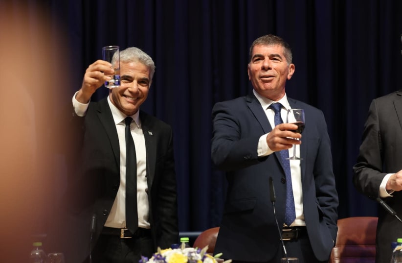 Foreign Minister and alternate Prime MInister Yair Lapid accepts his new role from his predecessor, Gabi Ashkenazi, June 14, 2021. (photo credit: MINISTRY OF FOREIGN AFFAIRS)