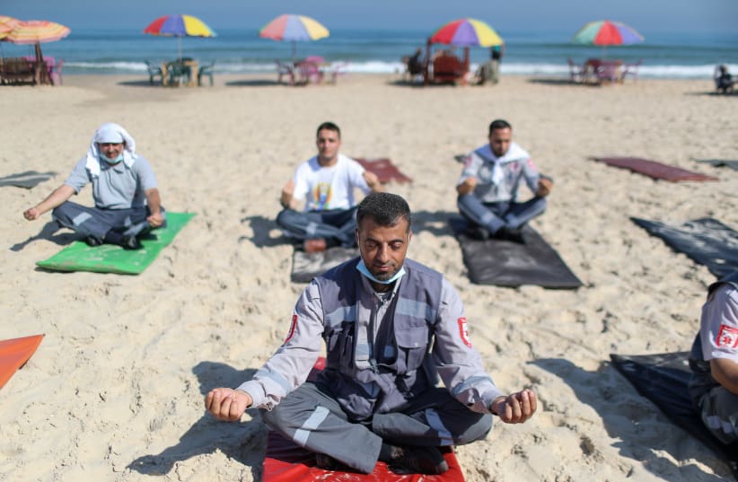 Palestinian paramedics perform yoga on International Day of Yoga, on a beach in Gaza City (photo credit: MOHAMMED SALEM/REUTERS)