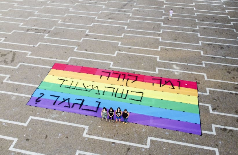Activists stand with Pride flag in Rabin Square (photo credit: KEREN MANOR)