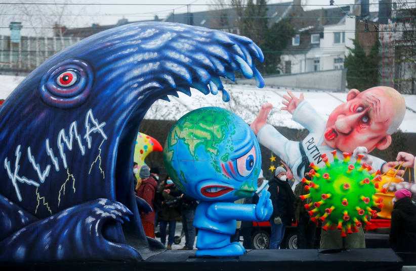 A CARNIVAL float depicts climate change, personification of planet Earth and the coronavirus in Duesseldorf, Germany, in February.  (photo credit: THILO SCHMUELGEN/REUTERS)