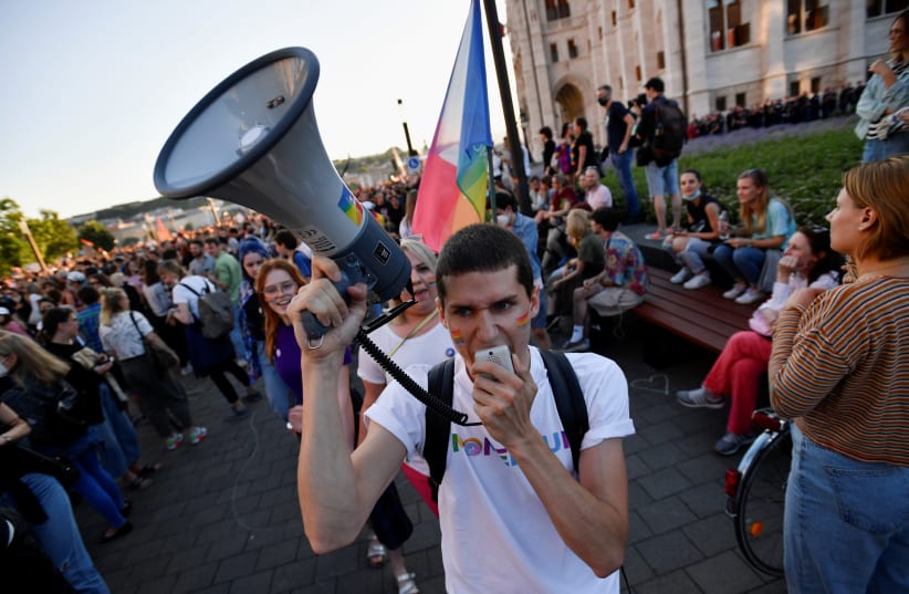 A demonstrator uses a megaphone during a protest against Hungarian Prime Minister Viktor Orban and the latest anti-LGBTQ law in Budapest, Hungary, June 14, 2021. (photo credit: REUTERS/MARTON MONUS)