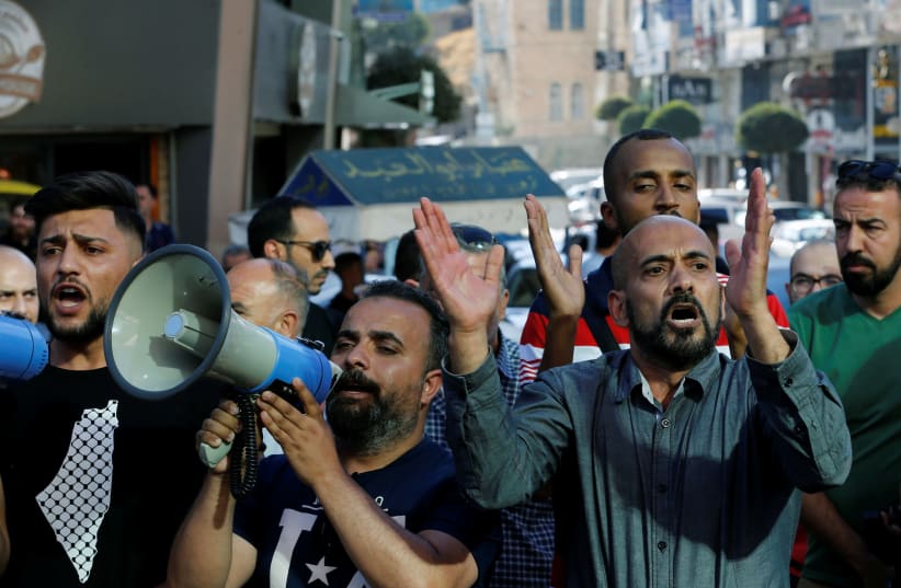 Demonstrators protest over the death of Nizar Banat, a critic of the Palestinian Authority, in Hebron, (photo credit: MUSSA QAWASMA/REUTERS)