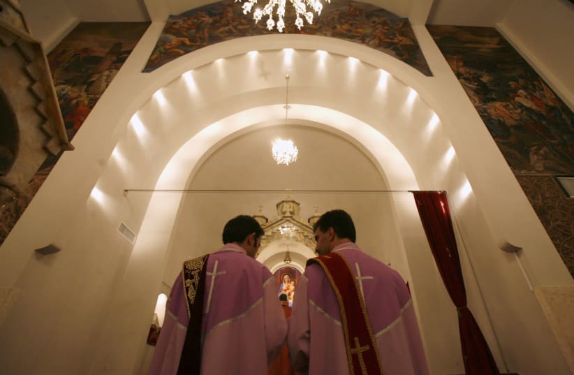 Iranian Christian priests pray during a new year mass at a church in Tehran. (photo credit: REUTERS/MORTEZA NIKOUBAZL)