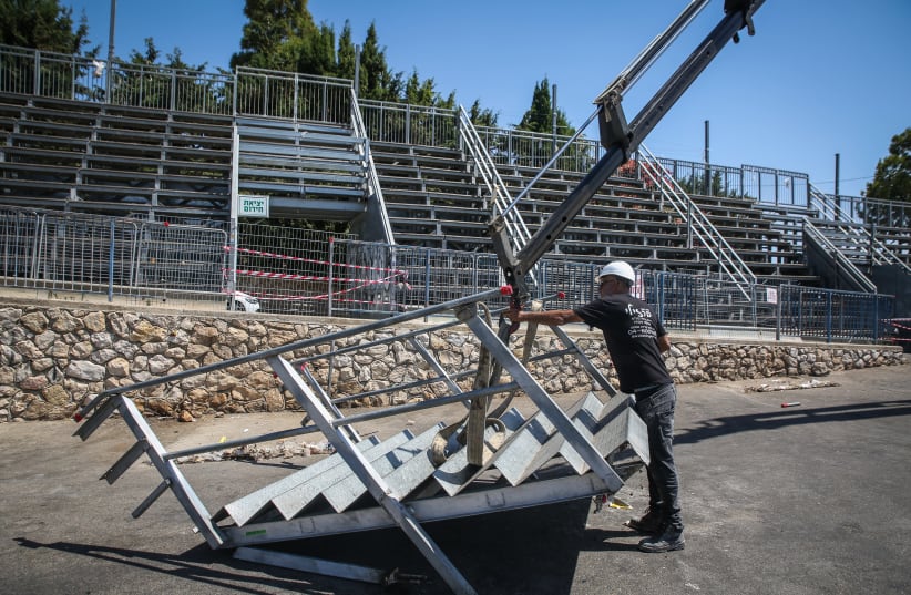 Workers are seen removing bleachers on Mount Meron, on July 1, 2021. (photo credit: DAVID COHEN/FLASH 90)