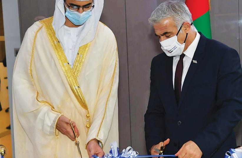 FOREIGN MINISTER Yair Lapid and Omar Sultan Al Olama, UAE minister of state for artificial intelligence, cut a ribbon during the inauguration ceremony of Israel’s consulate in Dubai, on Wednesday. (photo credit: SHLOMI AMSALEM/GPO)