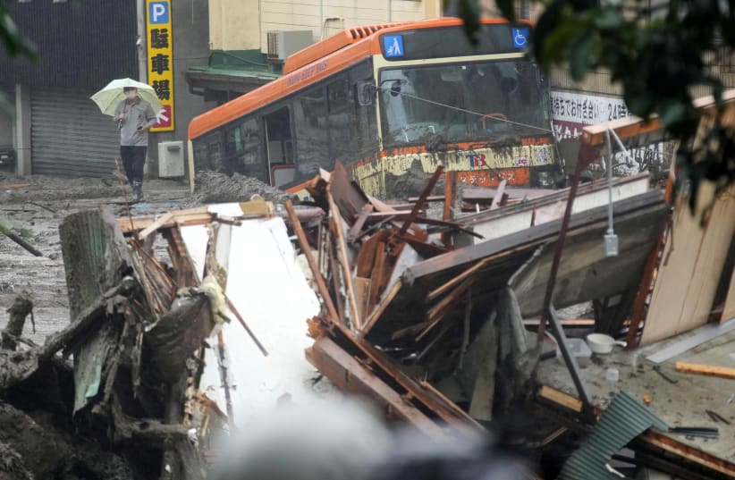 A damaged bus and debris of the houses are seen at a mudslide site following heavy rain at Izusan district in Atami, Japan July 3, 2021. (photo credit: REUTERS)