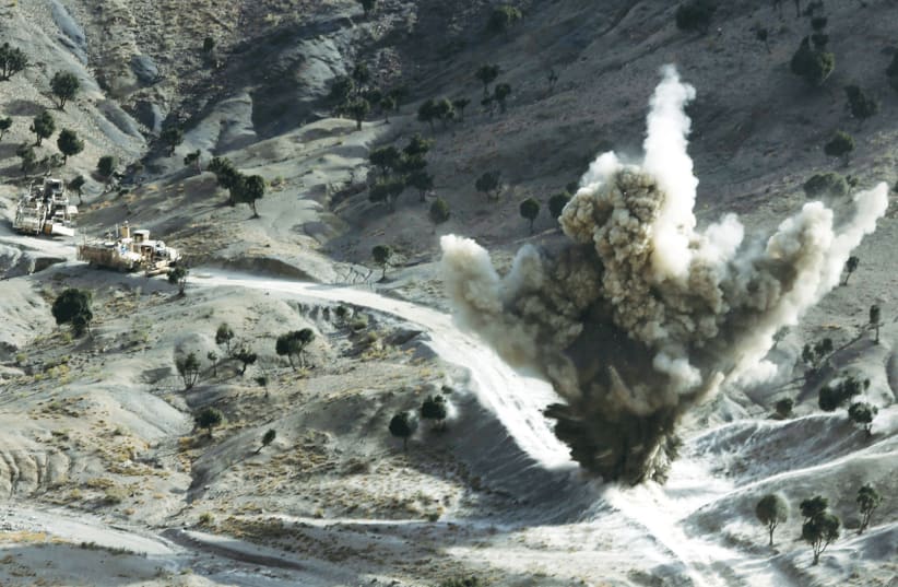 US SOLDIERS explode a roadside bomb set by Taliban fighters in Paktika Province, Afghanistan, near the Pakistani border, in 2012. (photo credit: GORAN TOMASEVIC/REUTERS)