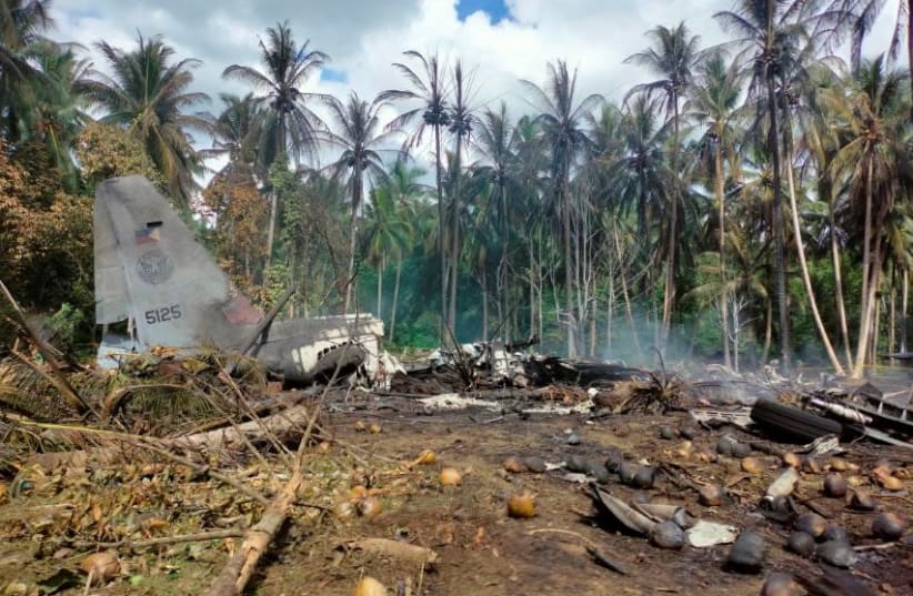 View of the site after a Philippines Air Force Lockheed C-130 plane carrying troops crashed on landing in Patikul, Sulu province, Philippines July 4, 2021. (photo credit: ARMED FORCES OF THE PHILIPPINES - JOINT TASK FORCE SULU/HANDOUT VIA REUTERS)
