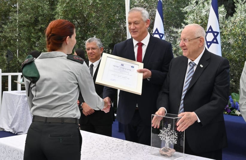 Defense Minister Benny Gantz and President Reuven Rivlin are seen awarding the Israel Security Prize to an unidentified individual at the President's Residence, on July 5, 2021. (photo credit: DEFENSE MINISTRY)