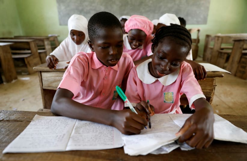 Two students during class at Ilorin Grammar school, in Ilorin, Kwara state, Nigeria, March 26, 2021.  (photo credit: REUTERS/TEMILADE ADELAJA)