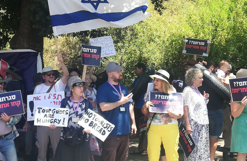 Israeli tour guides are seen protesting outside the Knesset as low tourism and no government benefits puts them in crisis, on July 6, 2021. (photo credit: ZEV STUB)